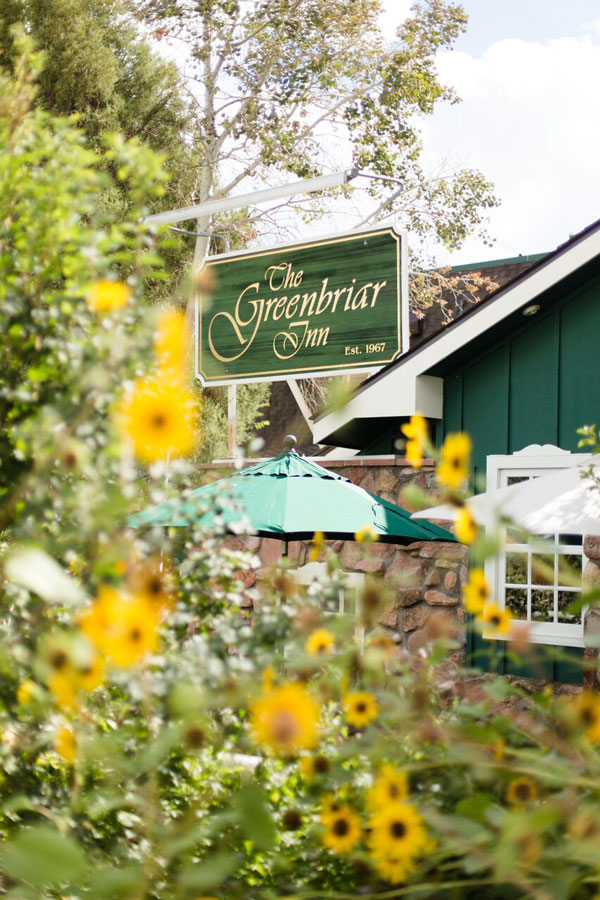 The Greenbriar Inn sign with sunflowers